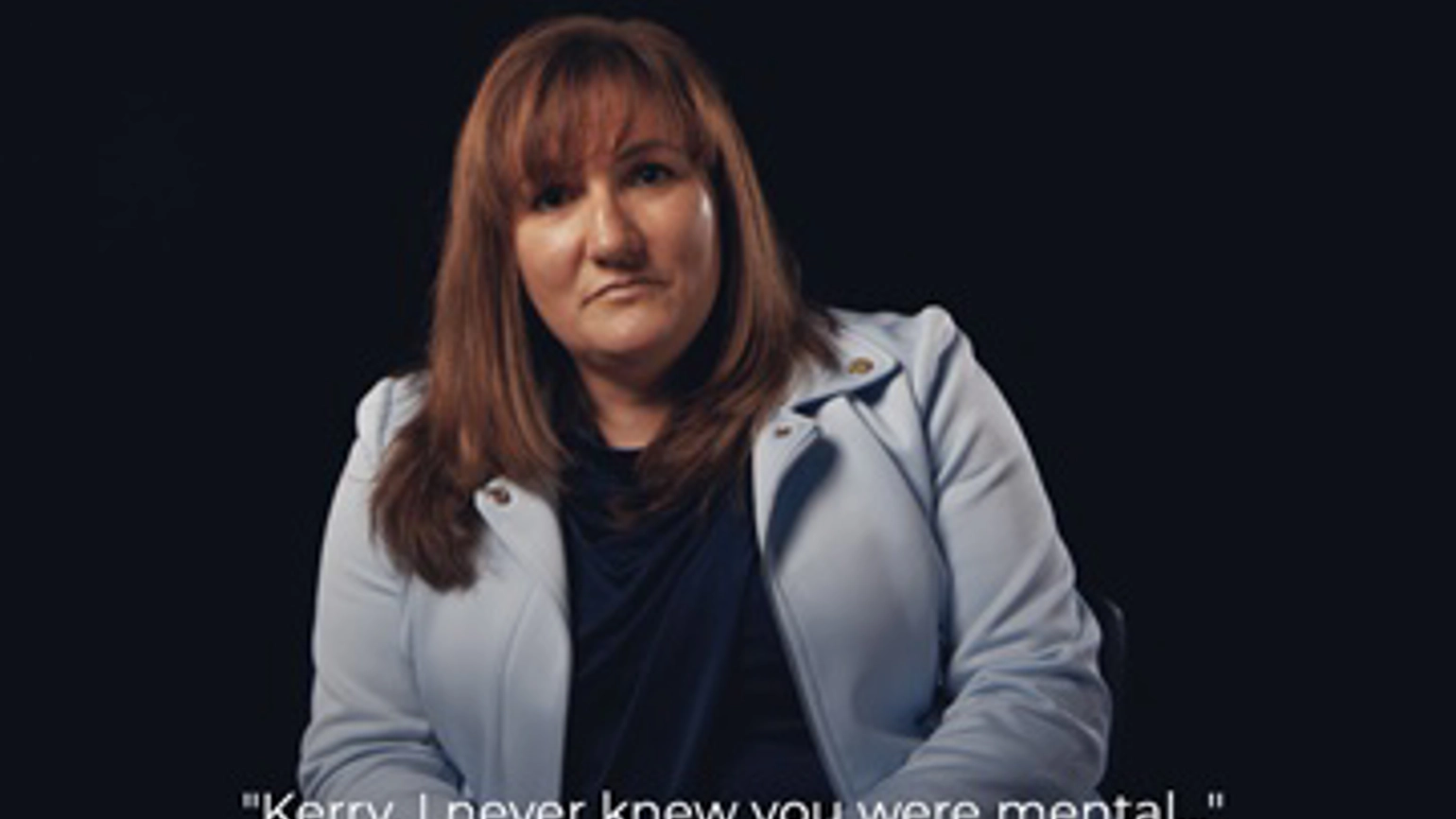 A woman is being interviewed in front of a black background