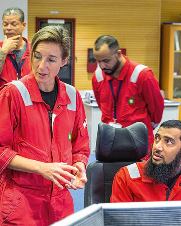 Photograph of BP workers in boiler suits in a meeting together