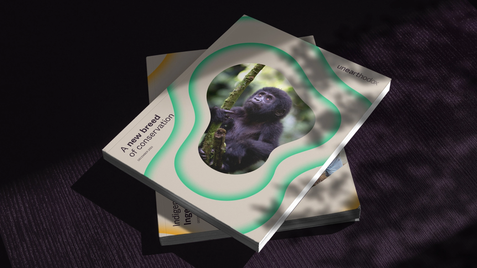 Two books, horizontally stacked against a dark background, the top one has an image of a gorilla on the front and reads 'A new breed of conservation'