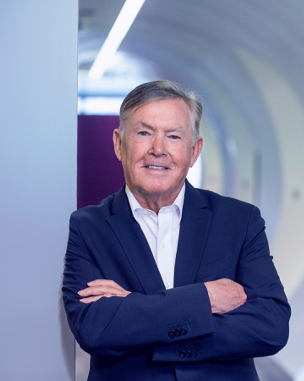 A middle-aged man in suit folding his arms